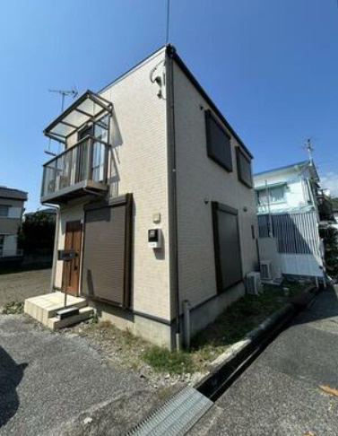 「日当たり良好3LDK」高知市薊野西町3丁目　中古一戸建ての前面道路含む現地写真|淡い色合いの外壁と木目調の玄関ドアが調和する、すっきりとした外観の2階建て住宅です。