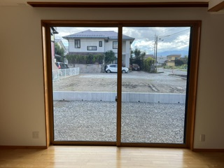 安曇野市豊科高家　中古戸建ての庭|リビングの窓から広がる南側庭先の景色。日中の明るさを確保。