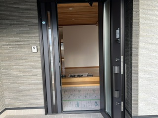 安曇野市豊科高家　中古戸建ての玄関|ガラスから光が差し込む玄関扉。明るく開放的な足元を演出。