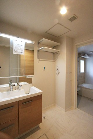 シャロムの洗面所|三面鏡タイプの洗面台＋洗濯機置き場の上に棚付き