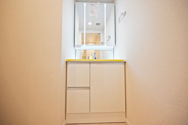 京橋第2コーポの独立洗面台|三面鏡タイプの洗面化粧台は、身だしなみを整えやすく、毎朝の準備もスムーズに行えます。鏡の裏側には小物類をすっきり収納でき、洗面スペースを清潔に保ちやすいのも魅力。家族みんなで使いやすい設備です。