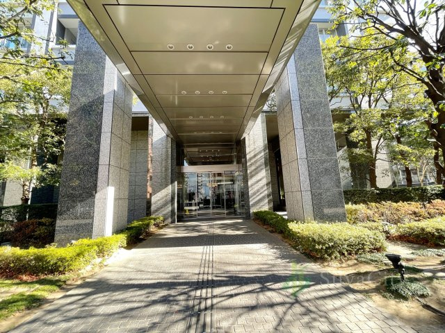 クレストプライムタワー芝のエントランス|緑豊かな植栽と重厚な石造りの柱が印象的なグランドエントランス。ゆとりあるアプローチが住まいへの期待感を高めます。都心にありながら落ち着きと品格を感じられる、タワーレジデンスの美しい玄関口です。