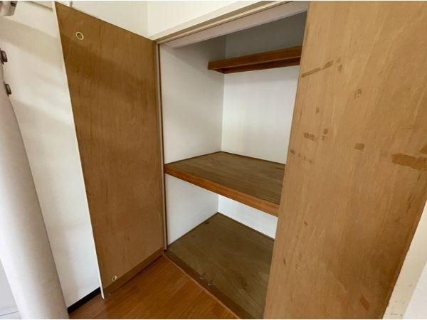 フレクション大分大在の収納|シンプルな木目調の収納スペースです。棚が設置されていて荷物の整理がしやすくなっています。扉付きで中身をすっきり隠せます。高さもあり様々な物を置ける仕様です。収納スペースの利便性が感じられます。