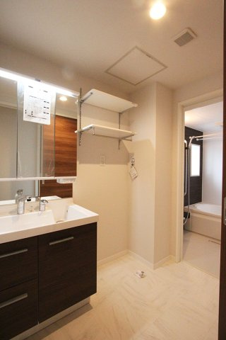 シャロムの洗面所|三面鏡タイプの洗面台＋収納棚や洗濯機置き場の上に棚付き