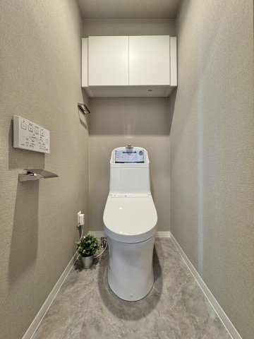 ジェイハイム東浜松のトイレ|ナチュラルな色合いで落ち着く空間になっています。背面上部には便利な収納棚付き！