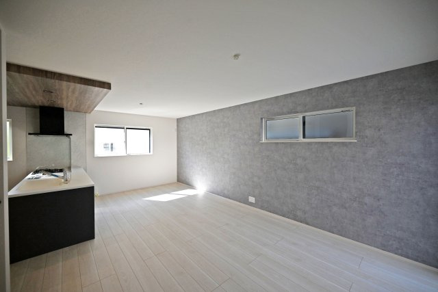 尼崎市富松町4丁目新築一戸建て│4LDK+駐車1台可の居間・リビング|1階LDK入ってすぐの内観写真です。 対面式キッチンやリビング階段で家族同士のつながりを感じやすい設計を基調としています。アクセントクロスを設けるなど、デザイン性を向上させた内観に仕上がりました。