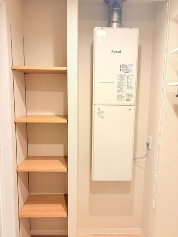 給湯器（Rinnai製）と使い勝手の良い可動棚収納が並んだユーティリティスペース。