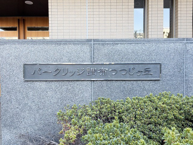 【現況写真】 | パークリッジ調布つつじヶ丘 | エントランスに掲げられた、マンション名を示す館銘板。さほど激しく主張はしませんが、しっかりと掲示されています。～即日のご見学可能～　お問合せはお気軽にどうぞ。