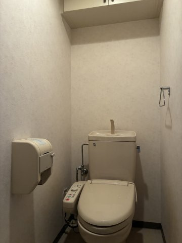 グランドール西条弐番館のトイレ|吊戸棚を備えたトイレ。トイレットペーパーや日用品の収納に便利です。