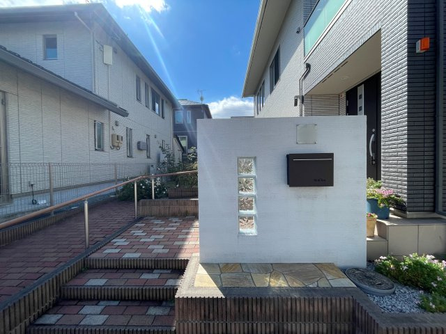 中古戸建・中古住宅　郡山市東原1丁目　富田東小・富田中の設備|ホワイトの塗り壁に縦一列のガラスブロックと黒いポストが組み合わされたモダンなデザインの独立型門柱♪