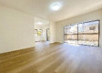 八王子市北野台　中古戸建の居間・リビング|約18.5帖のゆとりある大空間LDKです。大きな窓から自然光が差し込み、家族みんなでゆったりと心地よく寛げます。隣接する和室の引き戸を開放すれば、さらに開放的な空間として活用していただけます。