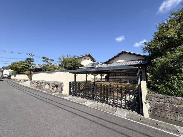 王ノ瀬1丁目　戸建ての駐車場|屋根付きの駐車場が備わっており車を直射日光や雨から守ることができます。門扉付きで防犯面も考慮されています。道路に面しているため車の出し入れもスムーズです。周囲は落ち着いた住宅街の雰囲気です。