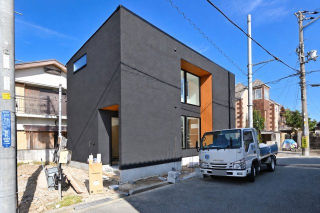 宝塚市中州2丁目新築一戸建て│3LDK+駐車1台可の外観|深みのあるダークグレーの外壁に、木目のアクセントが美しく映える外観。直線を生かした端正なフォルムと、縦に並ぶ窓が印象的です。落ち着いた色合いの中に木のぬくもりを添えた、洗練されたデザインの住まいです。
