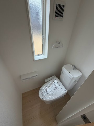 丸亀市土器町西第５　２号棟　４LDK新築２階建戸建　のトイレ|トイレは、ウォシュレット付きのシンプルなタイプになっています。紙巻器やトイレットペーパーの保管用棚もあらかじめ設置されています。