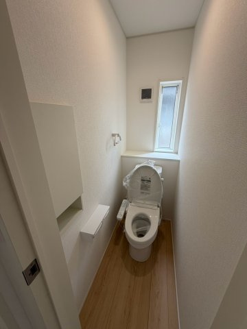 丸亀市土器町西第５　１号棟　４LDK新築平屋戸建　のトイレ|トイレは、ウォシュレット付きのシンプルなタイプになっています。紙巻器やトイレットペーパーの保管用棚もあらかじめ設置されています。