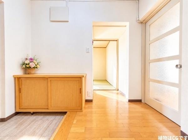 藤阪パークハイツ　１号棟　中古 マンションの玄関|明るい木目のフローリングと、温もりあるシューズ収納が調和する玄関ホール。ゆとりを感じる空間は、毎日の出入りも快適。奥へと続く廊下が住まいの広がりを感じさせ、家族や大切なお客様を心地よく迎えます。