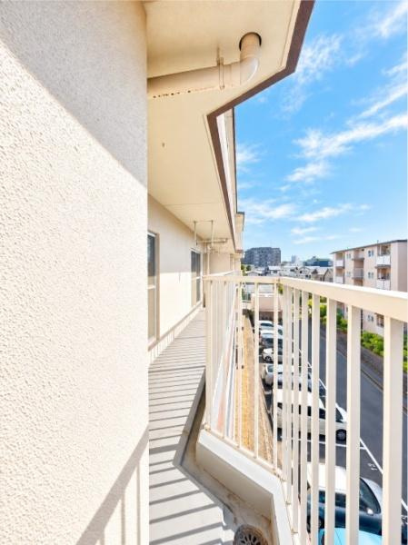 藤阪パークハイツ　１号棟　中古 マンションのバルコニー|爽やかな青空と街並みを見渡せる、開放感たっぷりのバルコニー。奥まで続くゆとりあるスペースは、毎日のお洗濯にも便利です。心地よい陽光と見晴らしの良さが、日々の暮らしに彩りを添えます。