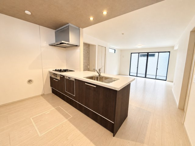 戸建 宇治市明星町３丁目のキッチン|落ち着いたダークブラウンのキッチンと、温かみのある木目調のアクセント天井が印象的♪ 明るいフローリングとのコントラストが美しい、おしゃれで洗練されたLDKです。