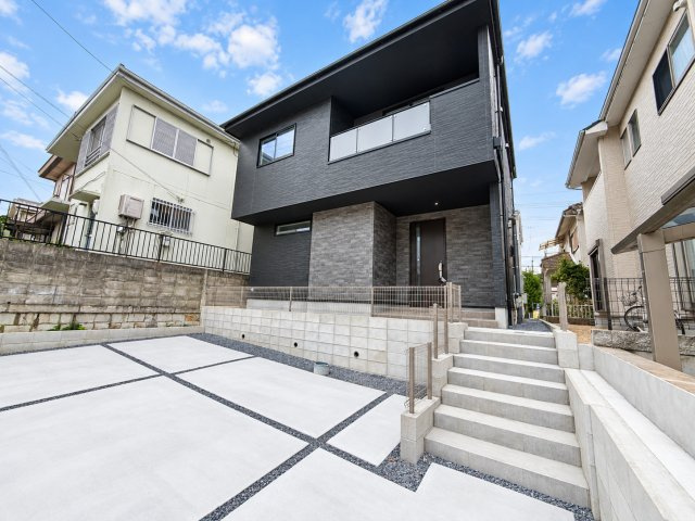 戸建 宇治市明星町３丁目の外観|ダークトーンの外壁とグレーの石目調が美しく調和するモダンな邸宅♪ 階段を上がった先に広がる落ち着いた玄関アプローチが、住まいに上質な雰囲気を添えます。
