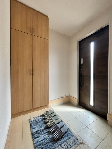 葛飾区細田4丁目売戸建の玄関|木目調の収納が温かみを添える玄関。すっきりと整った空間が家族やゲストを迎えます。
