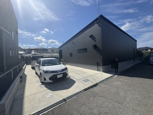 阪南市黒田　中古戸建の駐車場|青空に映える、落ち着いた色合いのモダンな平屋。駐車スペースもゆったり確保されていま