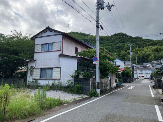 「小学校近く」高知市北竹島町　売地　建築条件無しの外観|背後に山の緑が見える現地。周辺の街並みや道路の様子もあわせてご覧いただけます。
