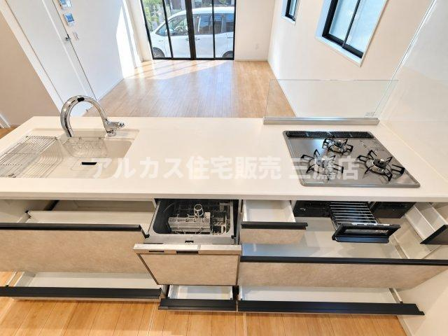 西東京市芝久保町3丁目 西武新宿線 花小金井駅 新築戸建のキッチン|シンク下やコンロ下にたっぷりとした引き出し収納と、便利なビルトイン食洗機を完備しています。調理器具や食器類をスマートに整理整頓できます。