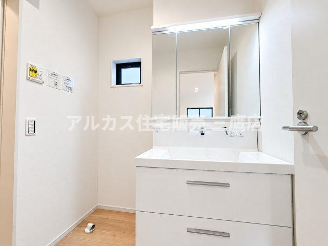 西東京市芝久保町3丁目 西武新宿線 花小金井駅 新築戸建の洗面所|三面鏡裏の豊富な収納とスライド式キャビネットを備えた使い勝手の良い洗面室。小窓からの採光と換気も確保されており、爽やかで快適なサニタリー空間を実現しています。