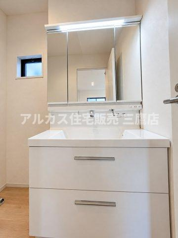 西東京市芝久保町3丁目 西武新宿線 花小金井駅 新築戸建の独立洗面台|明るいLED照明と三面鏡を備えた機能的な洗面化粧台。継ぎ目のないお手入れしやすいボウルと足元の引き出し収納で、毎日使う洗面空間をスマートかつ清潔に保てます。