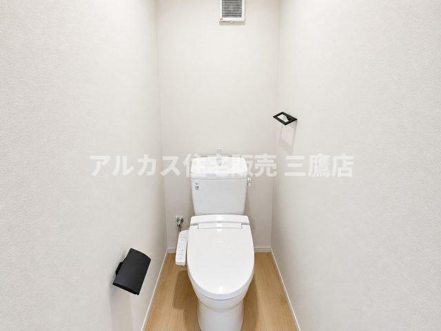 西東京市芝久保町3丁目 西武新宿線 花小金井駅 新築戸建のトイレ|清潔感溢れる白を基調としたトイレ空間。温水洗浄便座や手洗い付きタンクを備え、黒のペーパーホルダーがデザインのアクセントとして空間をスタイリッシュに引き締めます。