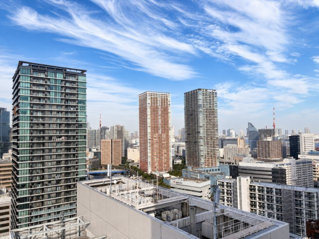 東京ベイシティタワーの展望|25階のバルコニーから望む開放的な都市景観。視界に広がる高層ビル群と青空が、都心のタワーマンションに暮らす醍醐味を感じさせます。