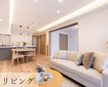 ライオンズマンション南大沢の居間・リビング|約14.8帖のゆったりとしたLDKです。間接照明やダウンライトが設置されており、温かみのある落ち着いた空間を演出します。隣接する洋室の扉を開放することで一体利用も可能です。
