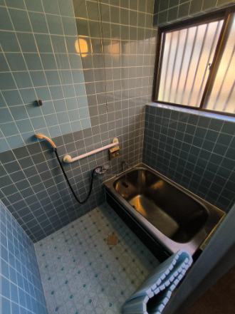 「和の趣あふれる物件」高知市春野町平和　中古戸建ての浴室|青系のタイルが印象的な浴室。
窓と手すりを備えています。設備の状態や広さも現地でご確認ください。