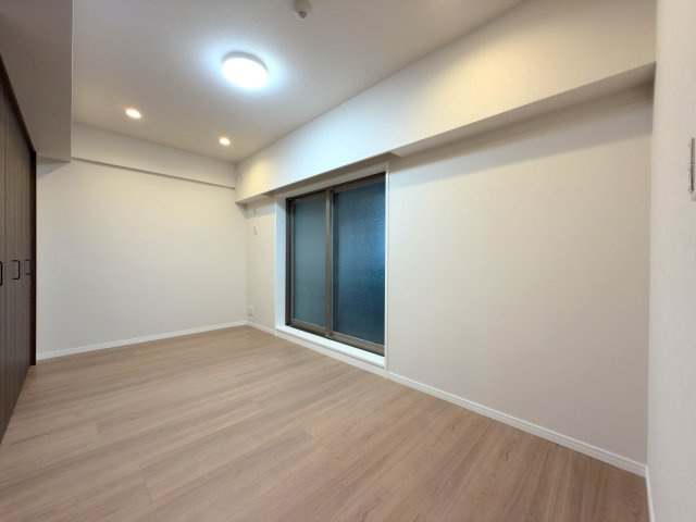 コスモシティ朝霞台の寝室|主寝室にゆとりをもたらす約6.5帖の洋室です。北西側のサービスバルコニーに面しており、心地よい通風を確保。ダブルベッドを置いてもゆとりのある広さで、毎日の休息を穏やかにサポートします。