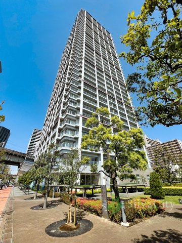 ベイクレストタワーの外観|青空に向かって伸びる地上40階建てのタワーレジデンス。洗練された外観デザインと豊かな植栽が調和し、港南エリアの街並みに存在感を放ちます。