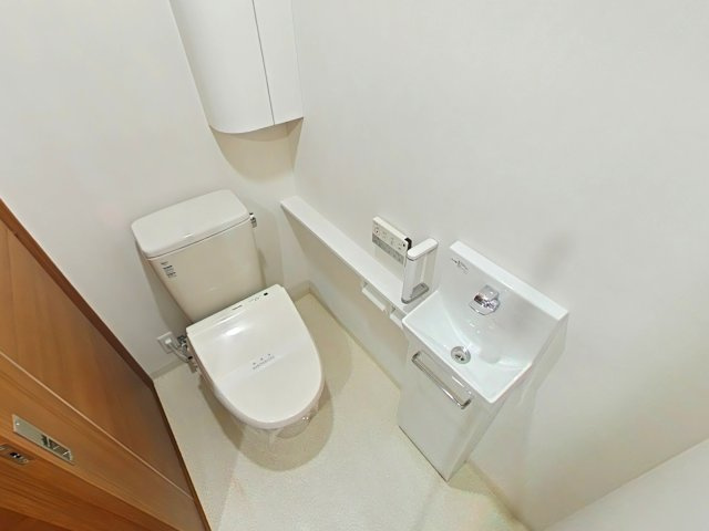 リビンコートプライム京山のトイレ|便利な独立手洗い器やカウンター、上部吊戸棚を備えており、トイレットペーパー等の収納にも困りません