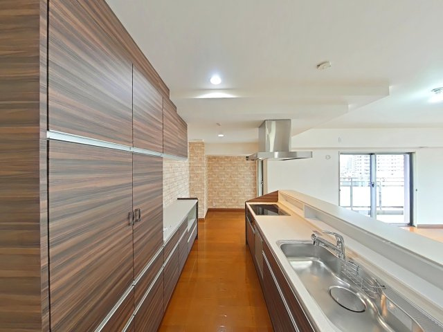 リビンコートプライム京山のキッチン|木目調の洗練されたキャビネットが空間を彩り、お気に入りの食器や家電を並べる時間が楽しくなります