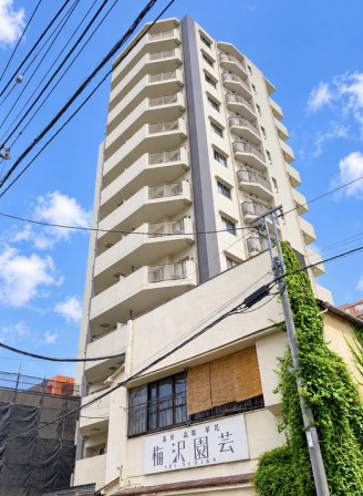サニーコート八王子第2の外観|日当たりが良い青空に映える地上13階建てのマンションです。防犯面で安心感のあるオートロックや、不在時でも荷物を受け取れる宅配ボックスを備えており、毎日の暮らしをスムーズに支えます。