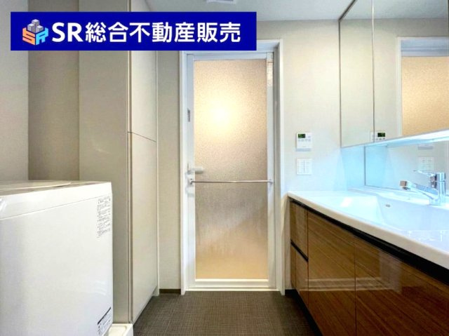 レ・ジェイドシティ 瓢箪山の脱衣所|幅広の収納たっぷりな三面鏡洗面化粧台と室内洗濯機置場がございます！（AIにて残置物削除）
タオル等を収納できる棚もあり便利です！