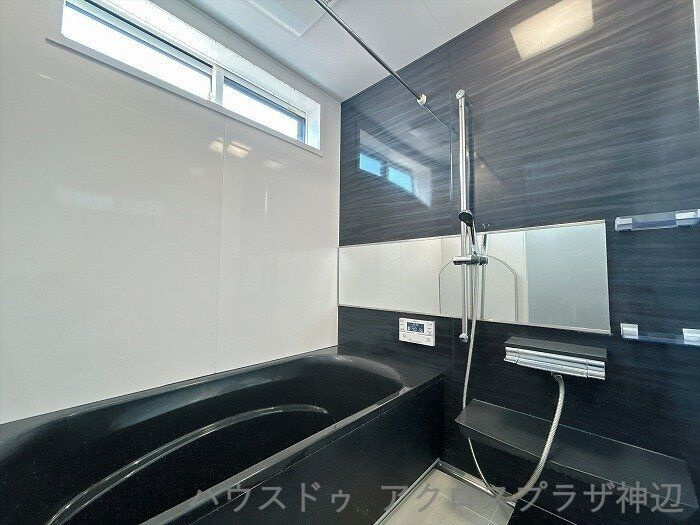 北吉津町3丁目の浴室|【浴室】ダークトーンのアクセントクロスと黒の浴槽が洗練された空間を演出。横長鏡が奥行をプラスし、一日の疲れを癒せる落ち着いたバスルームです。