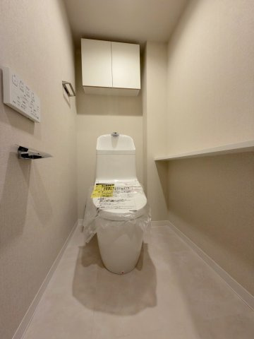 グリーンハイツ流山のトイレ|快適な温水洗浄便座を標準装備した清潔感のあるトイレ空間。上部にはトイレットペーパーや掃除用具のストックに便利な吊戸棚を設置しており、空間を無駄なくスマートにお使いいただけます。