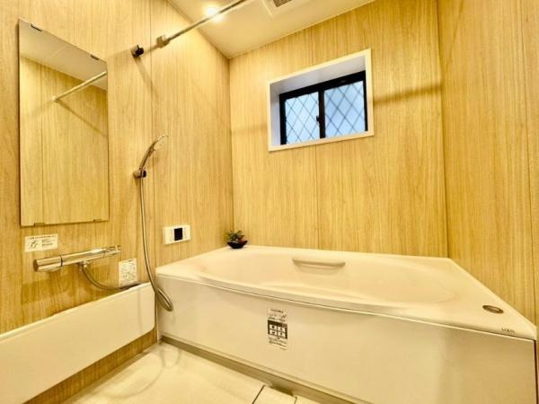守口市 佐太東町 ２丁目　中古 一戸建ての浴室|ナチュラルな木目調の壁が温もりを演出する、癒しのバスルーム。ゆったりとした浴槽で足を伸ばし、一日の疲れをリフレッシュ。窓付きで換気もしやすく、毎日の入浴が楽しみになる、くつろぎの空間です。