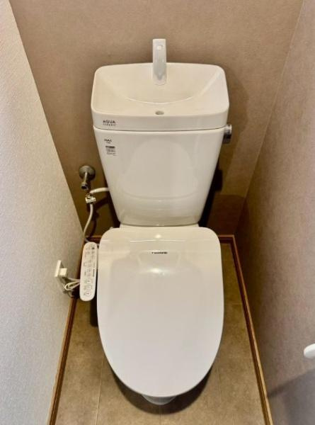 守口市 佐太東町 ２丁目　中古 一戸建てのトイレ|落ち着いたベージュの壁紙が上品で温かな雰囲気を演出するトイレ。温水洗浄便座と便利な手洗い機能を備え、毎日快適にお使いいただけます。シンプルながらも清潔感があり、ほっと落ち着ける心地よい空間です。