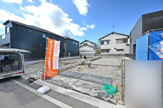 宝塚市高司3丁目新築一戸建て│4SLDK+並列駐車2台可の前面道路含む現地写真|建築工事に向けて準備が進む現地の様子。周辺には戸建住宅が建ち並び、前面道路や街並みの雰囲気もご確認いただけます。現地見学では、敷地の広さや道路との位置関係なども実際にお確かめください。