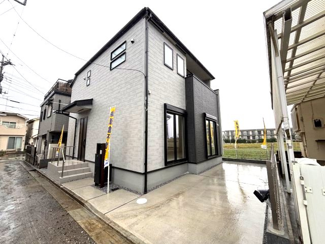 所沢市下安松　新築戸建ての前面道路含む現地写真|ホワイト×ブラックのツートンカラーが目を引くスタイリッシュな外観♪落ち着いたデザインで、飽きのこない住まいに仕上がっています！建物横には駐車スペースを確保し、毎日の車の出し入れにも便利です。