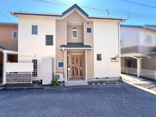 「収納豊富なリフォーム済み物件」高知市南河ノ瀬町　中古一戸建ての外観|白を基調とした外壁に、玄関まわりの石目調デザインがアクセントを添える2階建て住宅です。