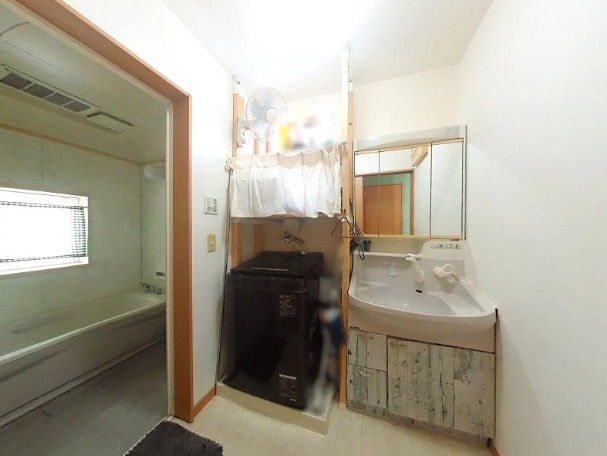 高知市南河ノ瀬町の中古一戸建の洗面所|洗面化粧台と洗濯機置場を備えた脱衣スペース。浴室が隣接し、入浴や洗濯がスムーズです。
