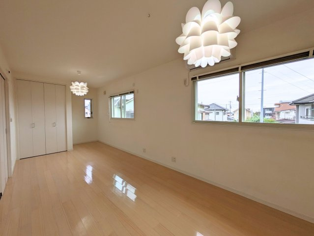 北土居5丁目戸建ての洋室|横に並ぶ窓と白いペンダント照明が印象的な洋室。淡い色の床が室内に柔らかな表情を添えます。