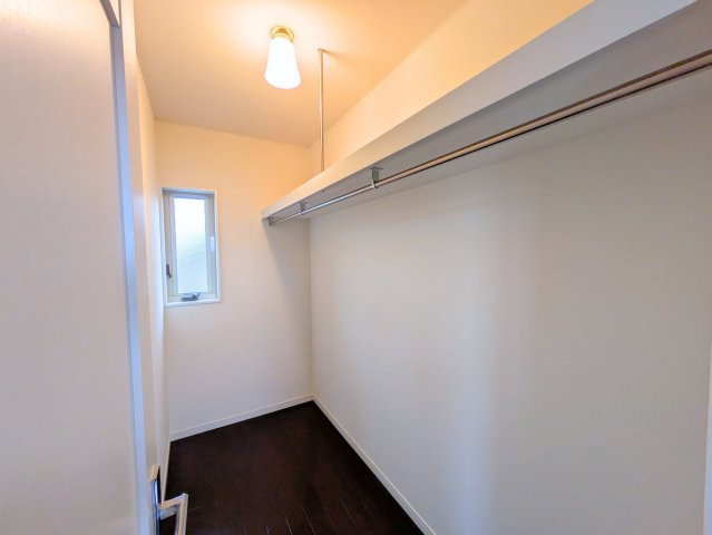 北土居5丁目戸建ての収納|衣類を掛けられるパイプと上部の棚を備えた収納。奥には縦長の窓があり、外光を取り込みます。
