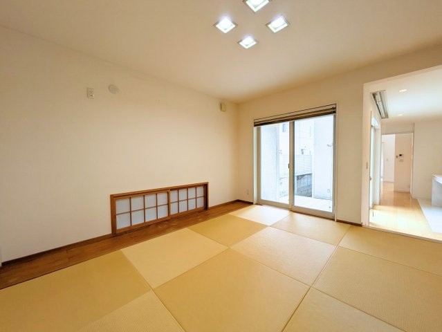 北土居5丁目戸建ての和室|縁のない畳を市松状に配した和室。低い位置の障子と掃き出し窓が、空間に表情を添えます。